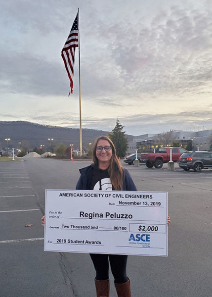 Regina M. Peluzzo, a civil engineering technology major from Philadelphia, holds an oversized scholarship check outside Pennsylvania College of Technology’s Student & Administrative Services Center. Peluzzo, who serves in the U.S. Air Force and is employed as a Veterans Affairs work-study student, was recently awarded $2,000 from the American Society of Civil Engineers’ Central Pennsylvania Section.