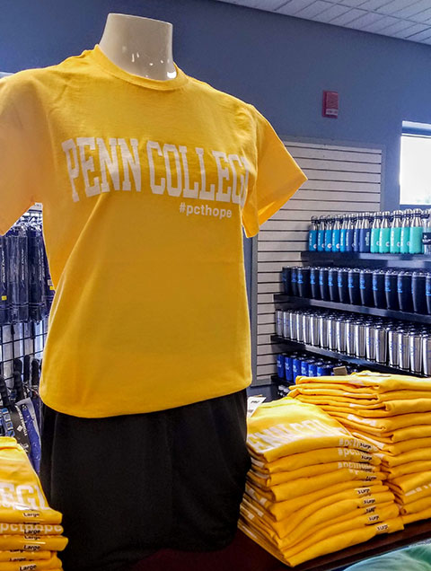 T-shirts, appropriately colored and bearing the #pcthope hashtag, await shoppers in The College Store.