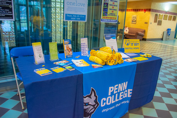 Resource tables at multiple locales, including this one in the Bush Campus Center, offer information and giveaways.