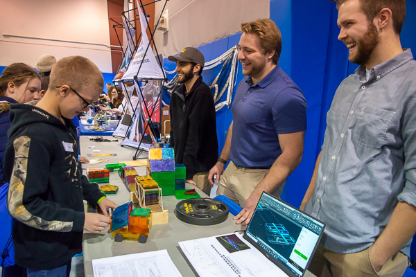 Representatives from Larson Design Group (on right) share a laugh with a student. On far right is alumnus Josiah T. Covert, ’18, civil engineering technology, who enjoys a career in bridge design and inspection.