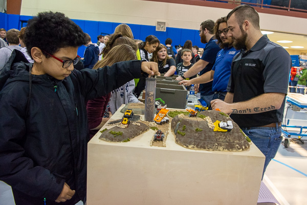 A fifth-grader pulls a core sample from the exploration table staffed by Penn College’s construction management students.