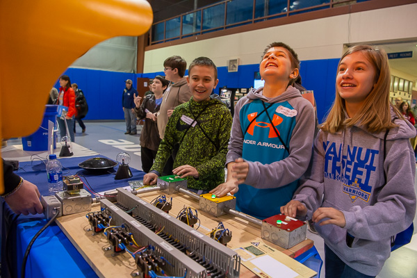 Students enthusiastically compete at a 24-volt traffic signal exhibit designed and built by Penn College electrical majors.