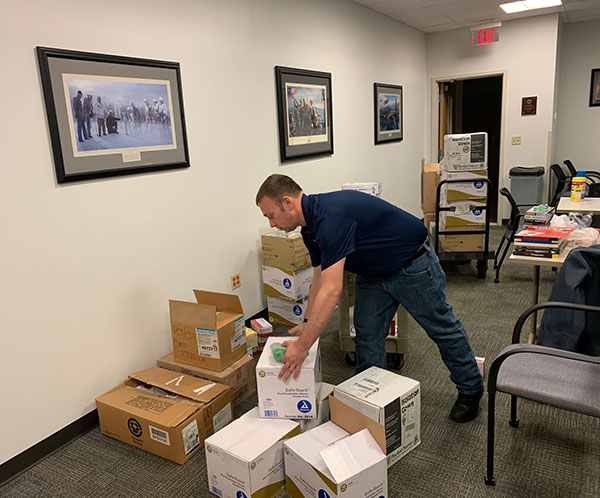 Timothy O. Rissel, executive director of General Services, sorts through boxes of donations.