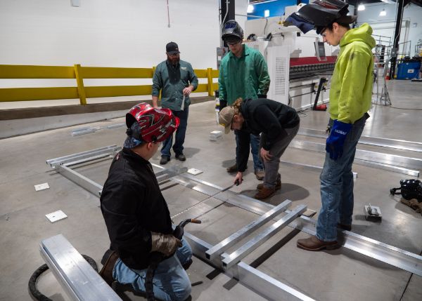 Students assist Ryan P. Good (far left), assistant professor of welding, in constructing the foundation for the Living Chapel. The walls’ bases slide into the foundation.