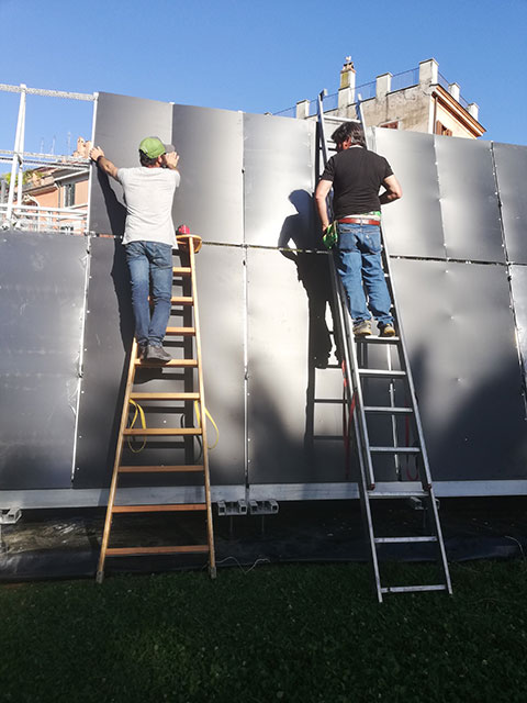 To prep for the flowers, PVC boards are bolted to the aluminum walls. 