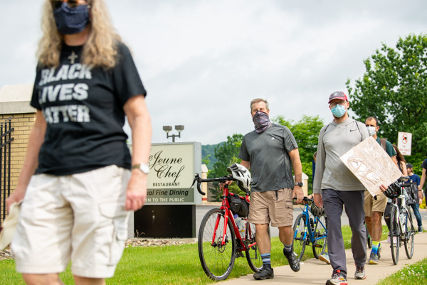 The peaceful protest aligns well with D. Robert Cooley (at center with red bike), associate professor of anthropology/environmental science, whose courseload includes Community and Organizational Change and Service Learning in Sociology.