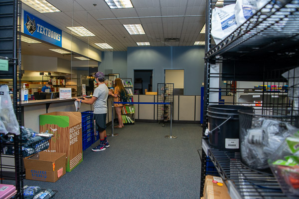 With the added safety of distancing and Plexiglas shields in The College Store, students pick up textbooks and supplies to start the semester.