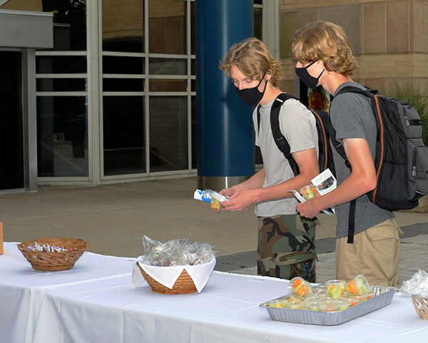 Three Wildcat Welcome tables – this one at the ATHS entrance, attracting first-year plastics students Jon J. and Jake T. Twardowski – provided convenient (and individually wrapped) goodies for the first day of fall classes.