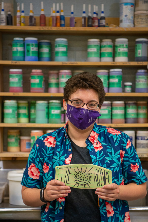 In the ceramics lab, Bri Milden, information technology: network specialist concentration, poses with “The Rona” mask. 