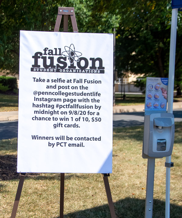 A sign of the times – a hand-sanitizing station – stands alongside a sign for a personalized event activity.