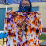 With a tie-dye-looking mask and purple-tinted hair, Abby E. Sneeringer, human services and restorative justice, blends in beautifully with the organization’s outdoor activity.