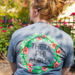 Roses outside the Campus Center complement this Theta Phi Alpha shirt worn by Caila N. Flanagan, business administration: management concentration.