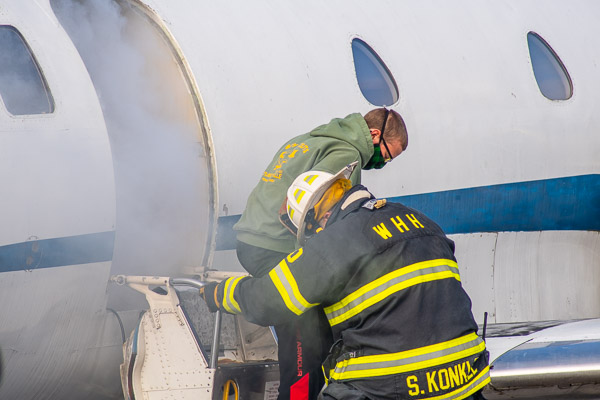 Willing Hand's Scott Konkle helps a student alight from the plane.