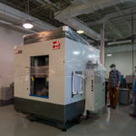 Students inspect the newly arrived Haas equipment in the automated manufacturing lab.