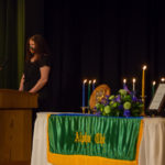 Chapter President Constance J. Plankenhorn explains the significance of membership and details Alpha Chi's ongoing involvement in spite of obvious challenges. Seated at right is Joanna K. Flynn, dean of instruction and curriculum, who welcomed attendees and outlined the campus's ongoing COVID guidelines. 