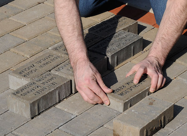Reber's brick is manuevered into position, with students' names – in placeholder mode from a 