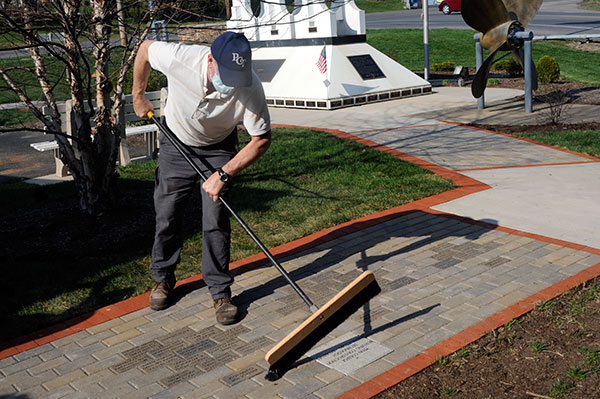 Hintz takes broom to pavement, the final touch in a job well-done.