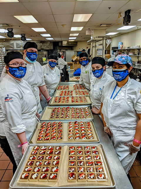 Pennsylvania College of Technology hospitality students, in a Churchill Downs kitchen, show a selection of the 10,000 tarts they made for 2021 Kentucky Derby fans.