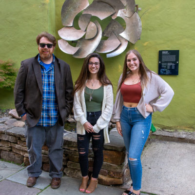 Faculty member Nicholas L. Stephenson and graphic design majors Alexa C. Henry (center) and Kaylee A. Smith stunningly updated the sign installed alongside the sculpture.