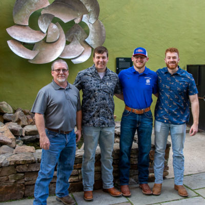 Welders who converted the once-freestanding artwork into a wall hanging are (from left) instructor Michael R. Allen and students Jeremy D. Carlson, Karl W. Machamer and Matthew G. Johnson.