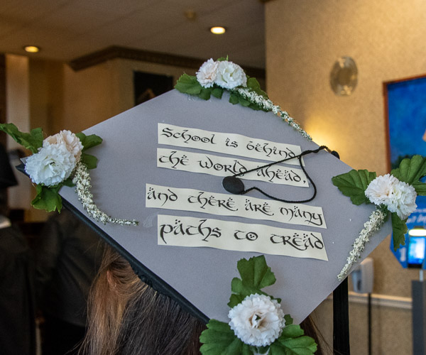 The forward-looking cap of Paige D. Picola, a building automation technology grad from Williamstown, modifies a song of traveling Hobbits.