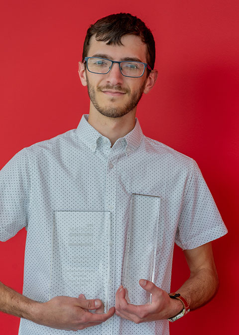 Tyler W. Miller, of Montgomery, holds two glass trophies received from the American Advertising Awards presented by the Northeast Pennsylvania Chapter of the American Advertising Federation. Miller earned Student Best of Show and a Student Gold, as well as a Judges’ Choice nod.