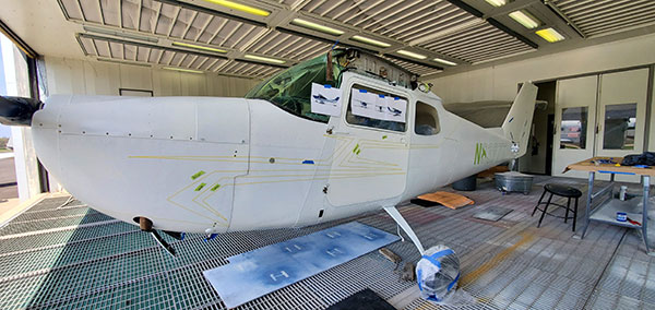 All of the surfaces coated in primer had to be sanded down, removing the glossiness so the topcoat could adhere. The design layout – drawn freehand by Ruggiero from multiple-angle photos of the paint scheme – can be seen in this photo of the reassembled fuselage, doors and tail section. Visible near the rear is the plane's 