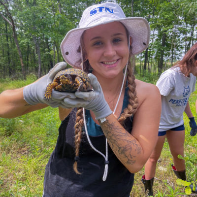 Sydney A. Bruno, of Williamsport, gets to know one of the creatures the tree farm aims to conserve.