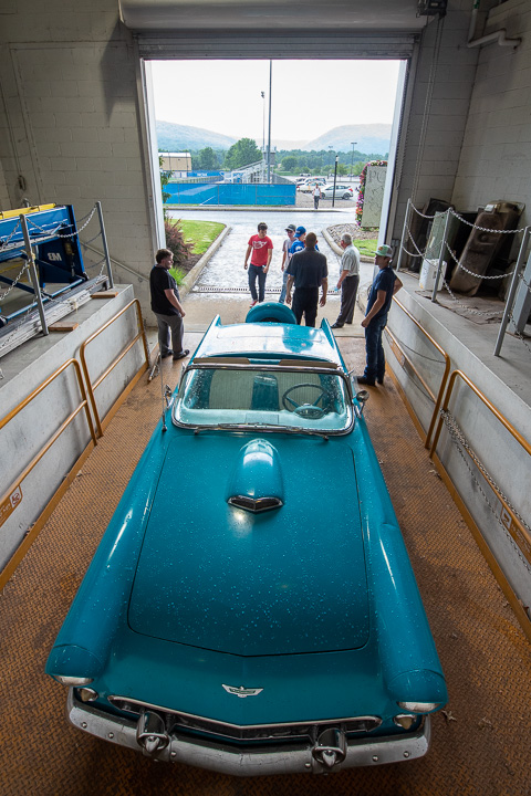 A cloudburst interrupted a student's enviable opportunity behind the wheel of a donated 1956 Ford Thunderbird convertible, necessitating a quick detour to the garage bay. Joining campers are Eric D. Pruden, automotive instructor, and Brett A. Reasner, assistant dean of transportation technologies.