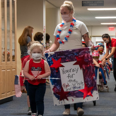 A star-spangled child leads the procession.
