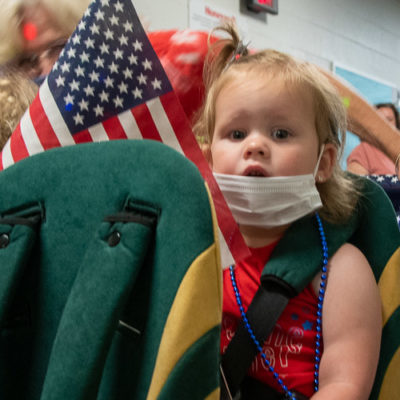 One of the youngest “marchers” watches the camera as the camera watches her.