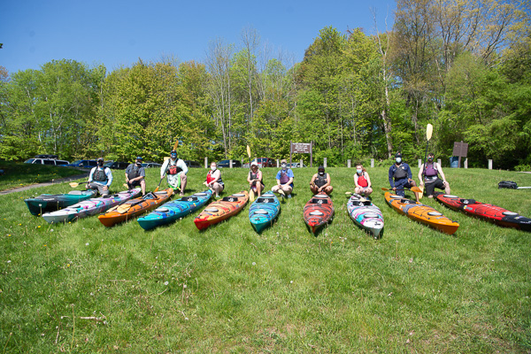 Cooley (left) joins his kayaking colleagues for a group photo at the lake's edge (taken while proximity carried a masking requirement).