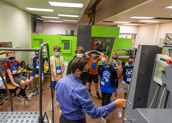Instructor Joshua J. Rice leads middle-school students through the college's renowned plastics facilities ...