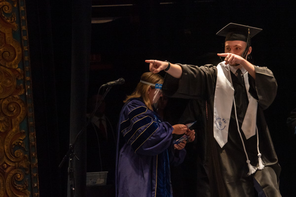 Wearing a white stole denoting membership in the Alpha Chi baccalaureate honor society, physician assistant graduate Charles T. Crawford, of Wilmington, Del., plays to his supporters.