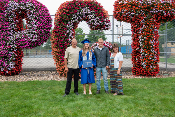 PTA grad Shayla M. Bickel, of Shinglehouse, is accompanied by her parents and brother in front of the blooming "PCT" on the west end of campus. Bickel, sporting a student-athlete sash, was an outfielder on the softball team that went to this year's NCAA Division III Championship tournament.