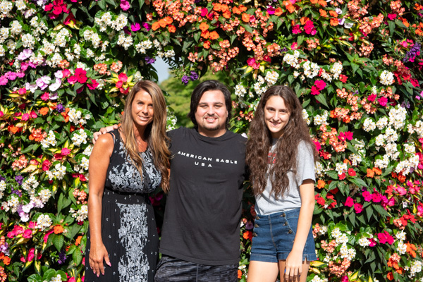 Nolan C. Johnson (center), of Montgomery, poses with his mother and girlfriend at one of the gorgeous flower features on campus. Johnson is enrolled in information technology: network and user support.
