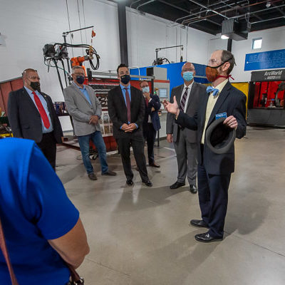 The tour group moves to a welding lab in the Lycoming Engines Metal Trades Center. At left (in red tie) is Rep. Joe Hamm (R-84), whose district includes part of Lycoming County.