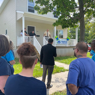 Duane Herberger (in yellow shirt), executive director of the Greater Lycoming Habitat for Humanity, addresses attendees at the home dedication.