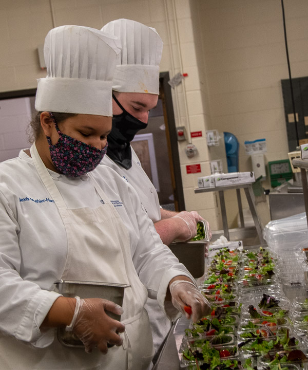 Culinary arts technology students Alexis J. Muthler-Harris, of Williamsport, and Lance P. Bierly, of Centre Hall, prep salads for the teams. Both are also part-time cooks for Le Jeune Chef.