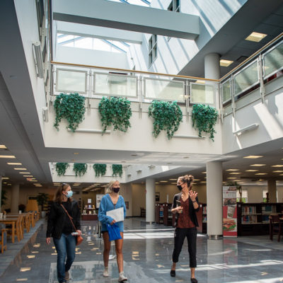 Christa Matlack (on right), head coach of women's soccer, takes a prospect and her mother through Madigan Library – just one of the visually appealing, awe-inspiring places on campus. 