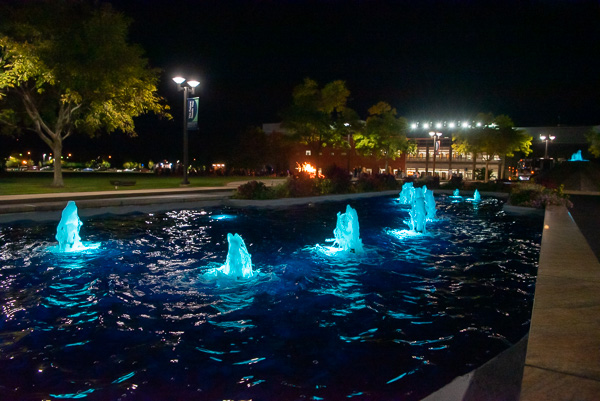The shimmering fountains at the college's main entrance, freshly turned on after a summerlong rehabilitation project, accent Friday night's bonfire on the library lawn.
