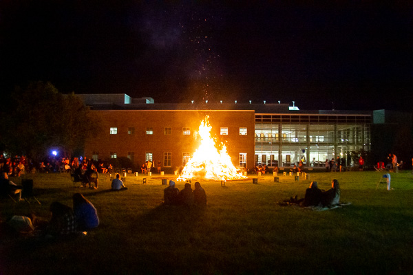 Bonfire attendees warmly gather (while socially distancing) on the first night of an eventful weekend.