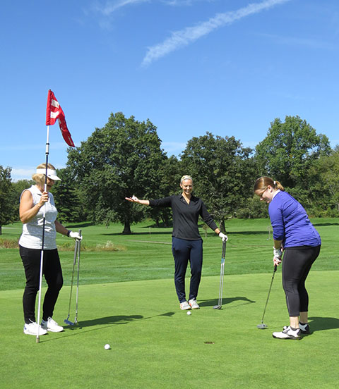 Kim Steimling sinks a putt, to the delight of teammates Kathy Poust (left) and Kati Wyland.