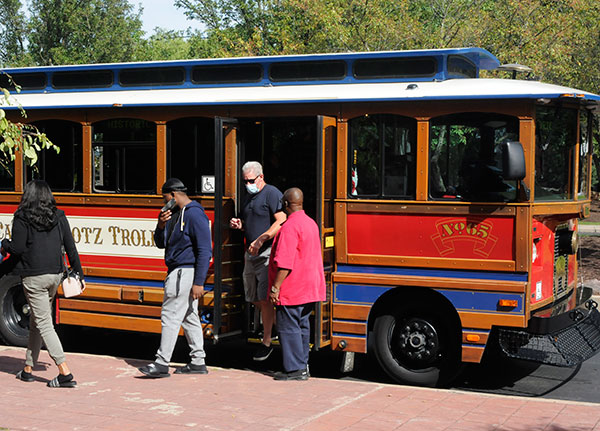 A tour group alights from a River Valley Transit trolley after returning to the Bush Campus Center. The excursions ran hourly for much of Saturday, providing a well-received glimpse of Millionaires' Row and its impressive Victorian Era mansions built by lumber barons.