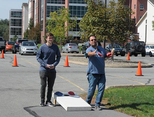 Art Skalski, of Cranford, N.J., tosses a cornhole bag while holding an ice cream cone ... 'cause that's just one of the things that dads can do. Son Michael E. (left) is a first-year electrical technology major.