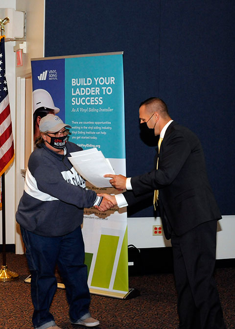 Rob Balfanz, the Vinyl Siding Institute’s director of workforce development, presents certification documents to Daun Williamson, a building construction technology major from Linden, during a Sept. 2 ceremony at Pennsylvania College of Technology. Williamson is among 29 Penn College students who attained Certified Installer status.