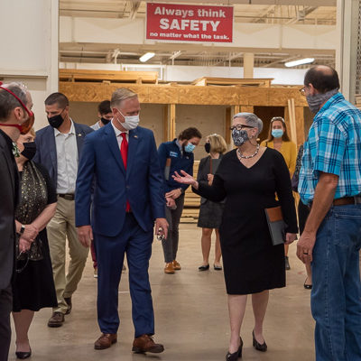 President Davie Jane Gilmour and the congressman lead the group through the BTC, where they toured building construction and HVAC labs. Enlightening the entourage are Bradley M. Webb (left foreground), dean of engineering technologies; Ellyn A. Lester (to Keller's right), assistant dean for construction and architectural technologies; and (in plaid) Peter Kruppenbacher, assistant professor of building construction technology.