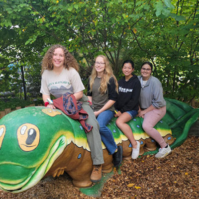 Students get acquainted with Parker the Caterpillar, a whimsical bench in the arboretum's Childhood's Gate garden.