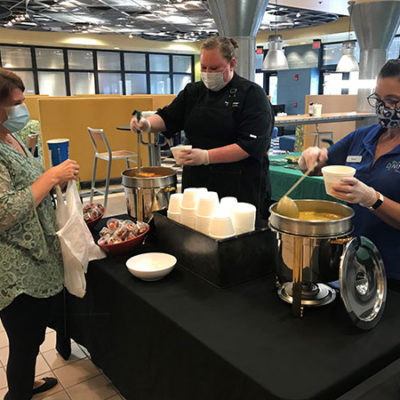 Jennifer N. Severson (center), head cook at CC Commons, and Denise M. Gardner-Butler, dining services worker, serve a Soup for the Soul patron.