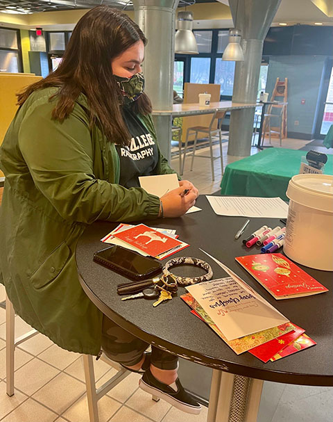 Applied health studies: radiography concentration student Anna A. Lovell composes her thoughts – and another note of sincerity – to armed-forces personnel. Lovell, of Galeton, represented the Medical Imaging Club at Saturday's service event.